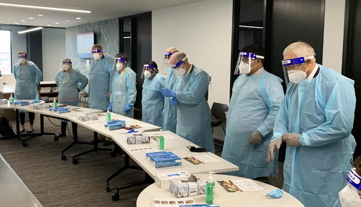 Regents learn appropriate PPE technique during a visit to the Health Sciences Education Center
